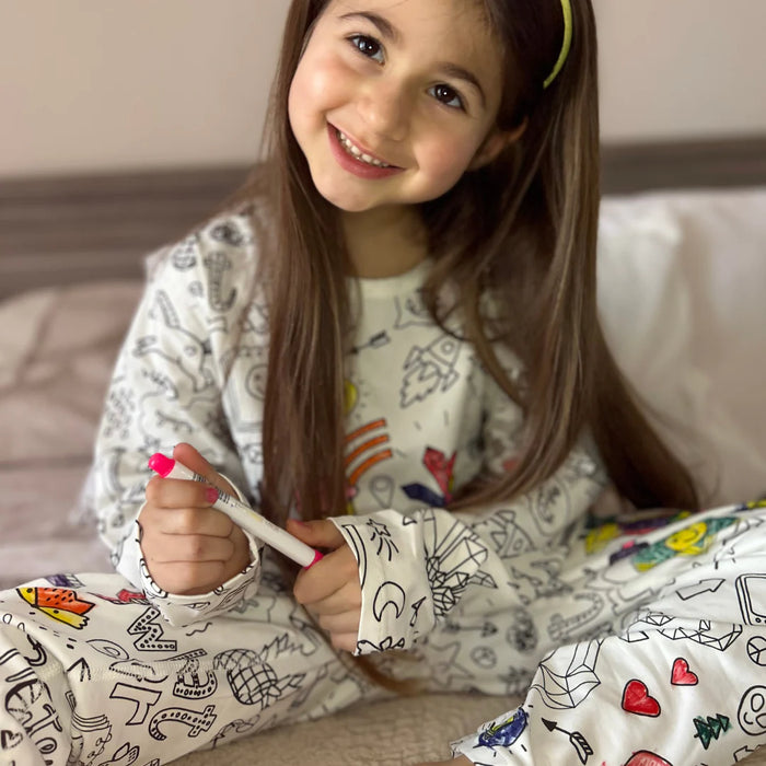 Gyerek a saját maga által kiszínezett Kiddo World pizsamában