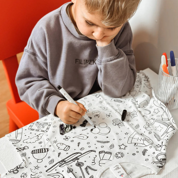 Gyerek a saját maga által kiszínezett Kiddo World pizsamában