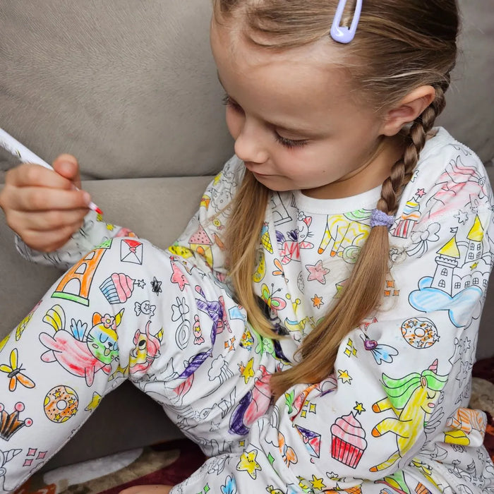Gyerek a saját maga által kiszínezett Kiddo World pizsamában